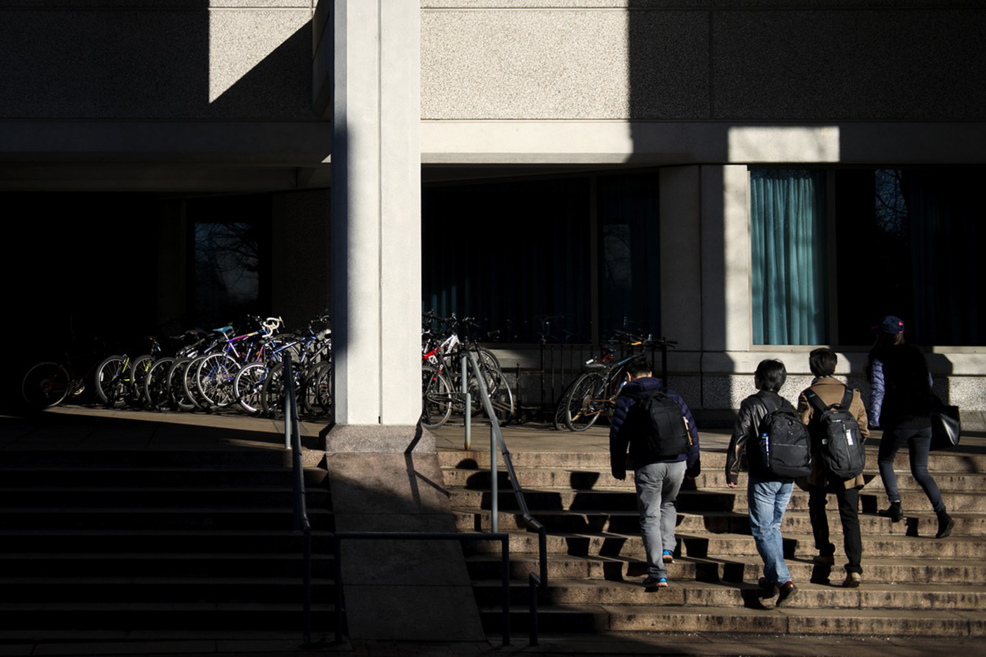 Students walks through a patch of light outside of Snell Library.