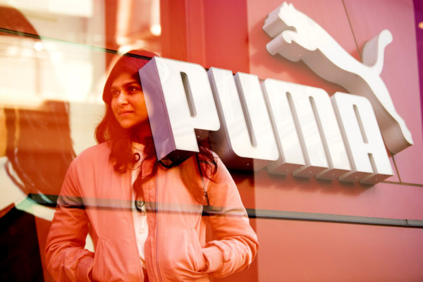 woman with long dark hair overlayed on puma logo on building