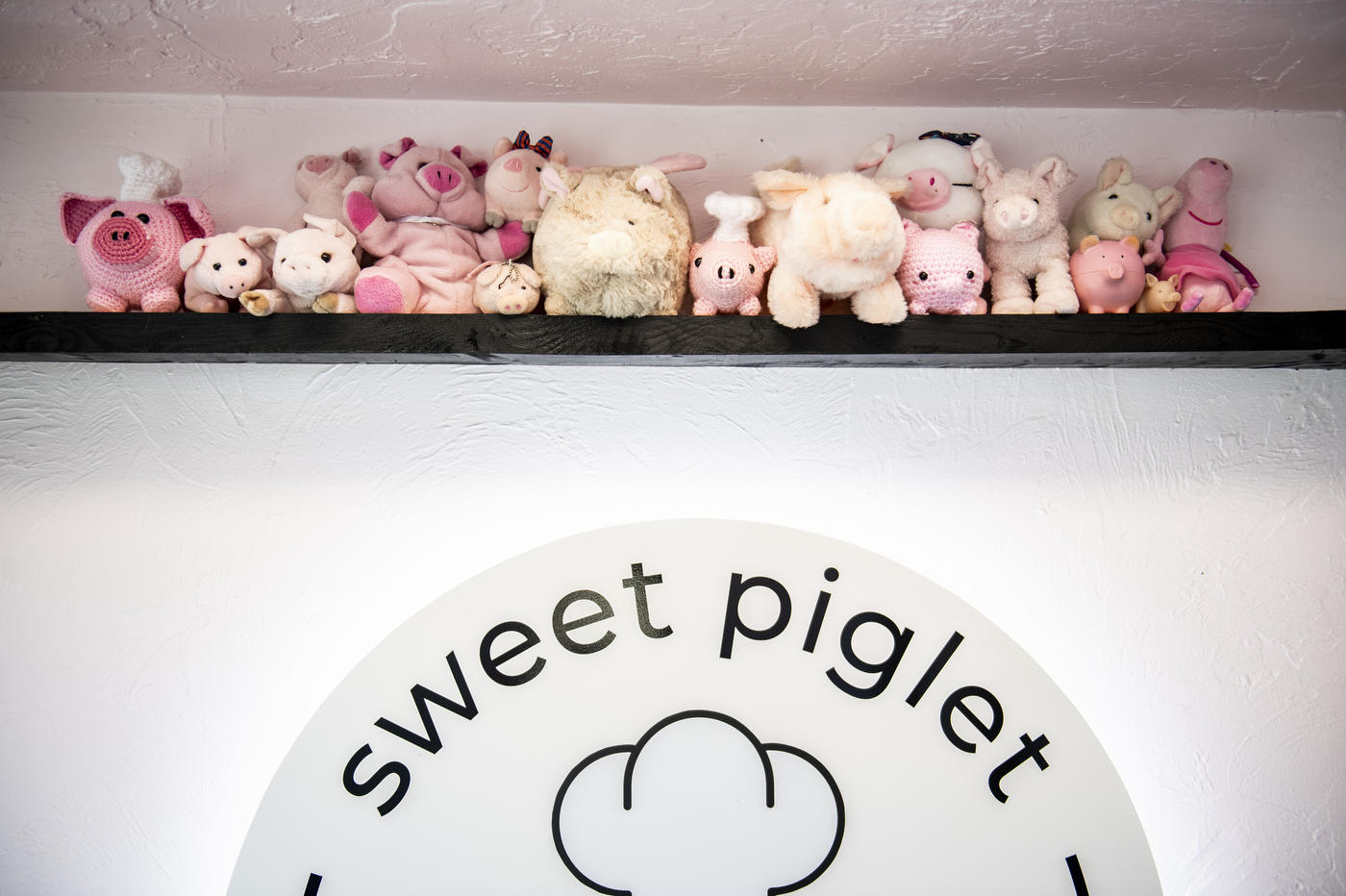 line of stuffed toy pigs on a shelf