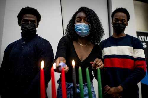 Northeastern students light the kinara for the annual Kwanzaa celebration at the John D. O’Bryan African American Institute. Photo by Alyssa Stone/Northeastern University