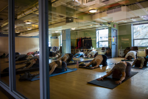  Students move through yoga poses during a yoga class in the Curry Student Center. Photo by Alyssa Stone/Northeastern University