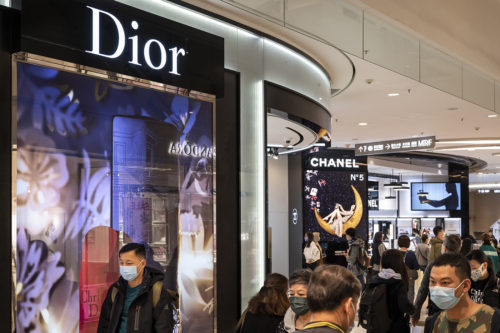 Shoppers walk past the French Christian Dior luxury goods, clothing and beauty products store seen in Hong Kong. Photo by Budrul Chukrut Sipa via AP Images