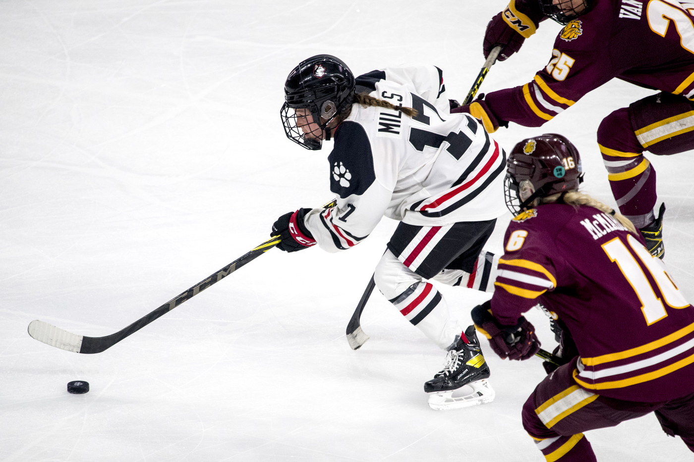Maddie Mills pushes the puck for Northeastern.