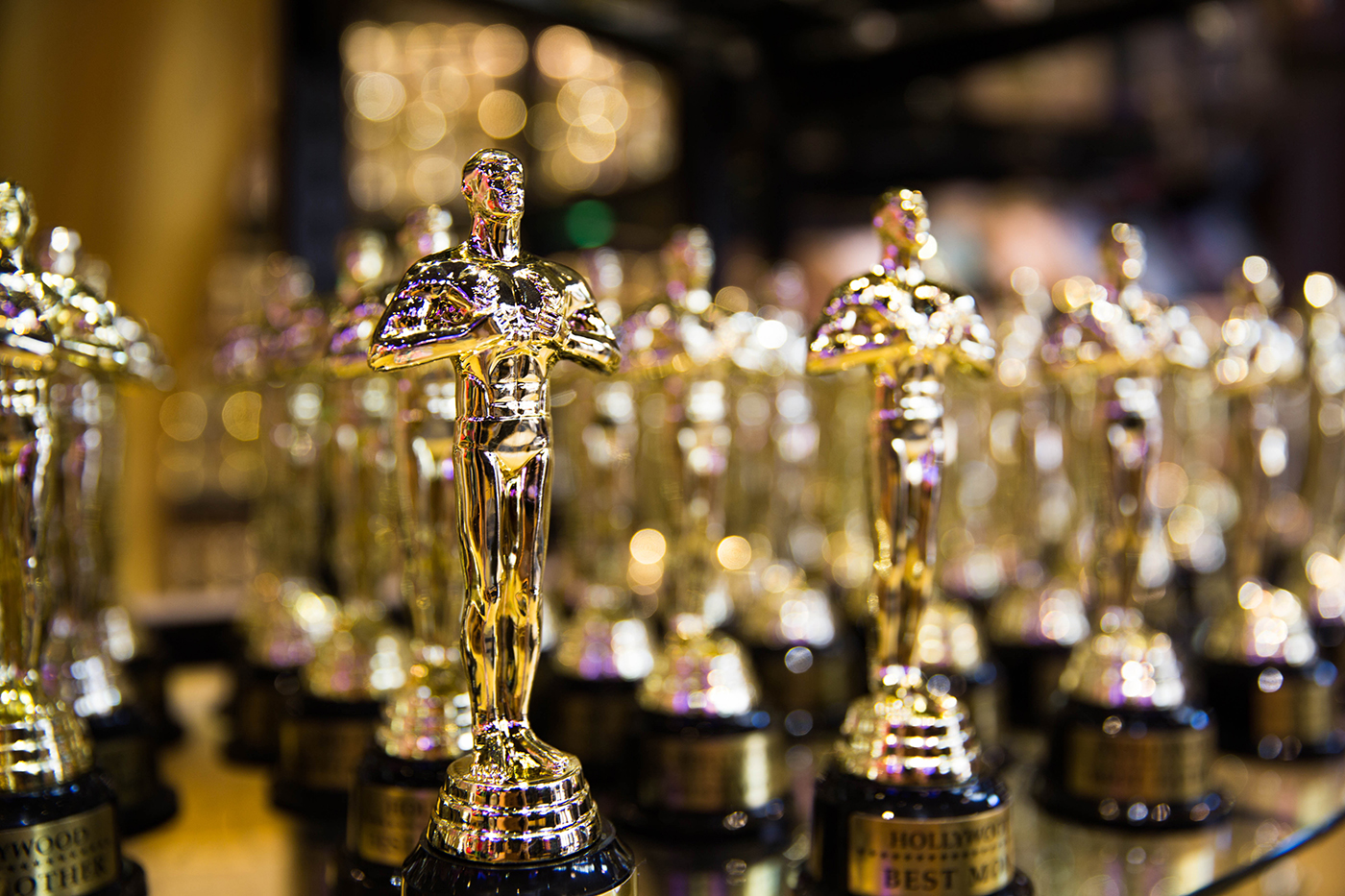 Academy Award Oscar statue with vintage movie reels on white Stock