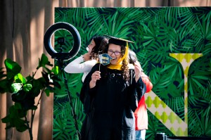 Northeastern graduates take photographs in the Cabot Center.