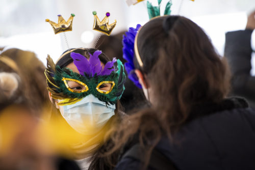 student wearing mardi gras mask