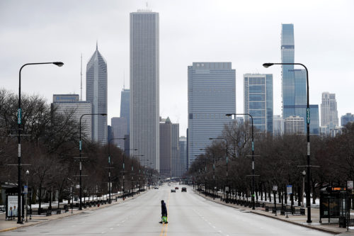 A solitary pedestrian walked across the usually busy Columbus Drive, which bisects Chicago’s Grant Park, on the first work day after Illinois Gov. J.B. Pritzker gave a shelter-in-place order in March. (AP Photo/Charles Rex Arbogast)