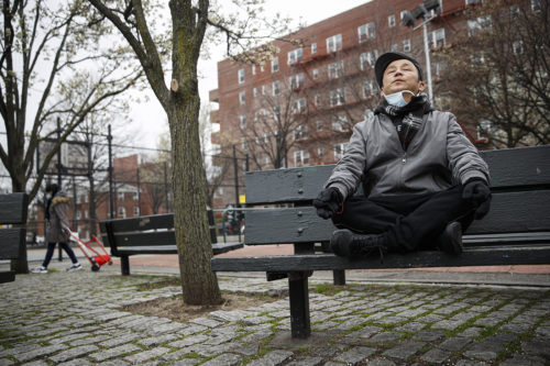 Lobsang Tseten meditates and practices breathing exercises alone to maintain “social distancing” at a playground on Wednesday, March 25, 2020, in New York. AP Photo/John Minchillo