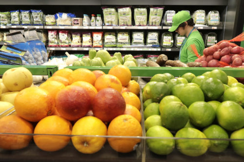On Feb. 21, 2020, a worker checks items on a shelf in the produce section of an Amazon Go Grocery store in Seattle's Capitol Hill neighborhood. (AP Photo/Ted S. Warren)
