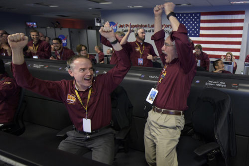 In this image provided by NASA, Mars InSight team members Kris Bruvold, left, and Sandy Krasner rejoice, Monday, Nov. 26, 2018, inside the Mission Support Area at NASA's Jet Propulsion Laboratory in Pasadena, California, after receiving confirmation that the Mars InSight lander successfully touched down on the surface of Mars. (Bill Ingalls/NASA via AP)