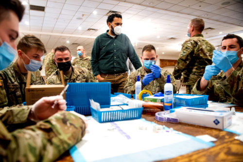 Thomas Matta, an assistant clinical professor, and members of the National Guard, fill Pfizer vaccines at Florian Hall in Dorchester, Massachusetts. Photo by Matthew Modoono/Northeastern University