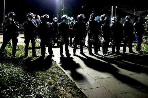 Police officers stand guard at City Hall in New York as protesters gather near an encampment outside on June 30, 2020. AP Photo/John Minchillo