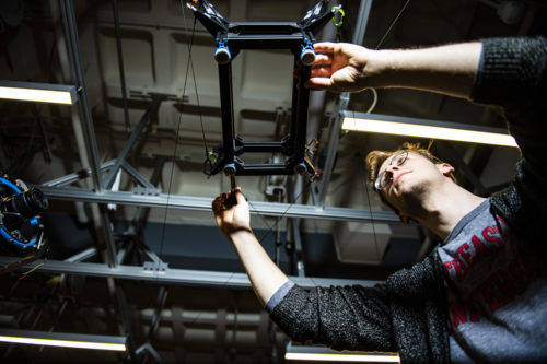 Northeastern computer engineering student Philip Andress makes adjustments to the cable driven robot in the Richards Hall lab where the Robotics club works. The clubs membership has grown exponentially since it's resurgence after the pandemic.  Photo by Alyssa Stone/Northeastern University