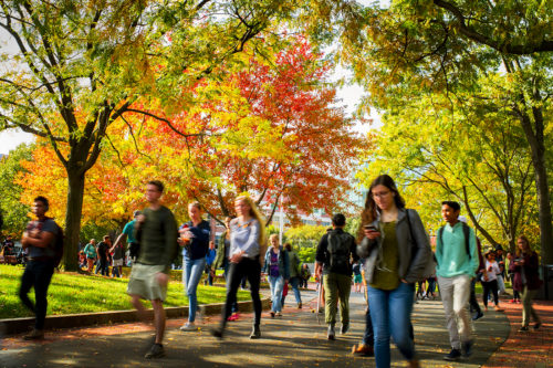 In this file photo, students walk to class against a backdrop of fall foliage. Photo by Matthew Modoono/Northeastern University