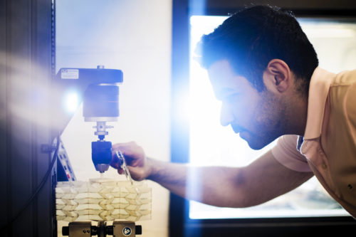 Soroush Kamrava, a doctoral student in mechanical engineering, works on a 3D printed sample in the Forsythe Building on July 12, 2018. Photo by Adam Glanzman/Northeastern University
