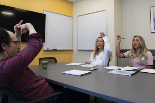 Sabrina Bender and Olivia Fahey, graduate students in Northeastern’s Speech-Language Pathology program, go through speech exercises with Rob Jacobson, who has Parkinson’s disease, in the Forsyth Building. Photo by Alyssa Stone/Northeastern University