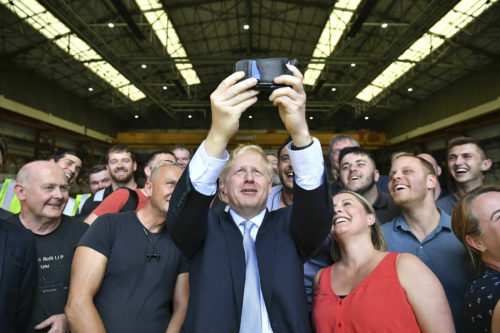 Conservative leadership candidate Boris Johnson takes a selfie with workers at the Wight Shipyard Company at Venture Quay during a visit to the Isle of Wight, England. (Andrew Matthews/Pool Photo via AP)