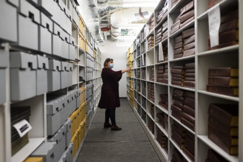 Head of Special Collections and University Archivist at Northeastern University, Giordan Mecagni looks through the Snell library stacks at The Boston Phoenix photo archives. Photo by Alyssa Stone/Northeastern University