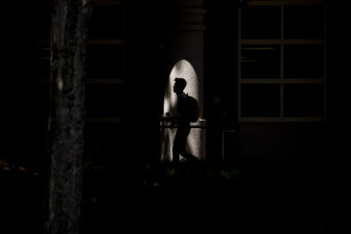 A Northeastern student is silhouetted against Shillman Hall during class break. Photo by Matthew Modoono/Northeastern University