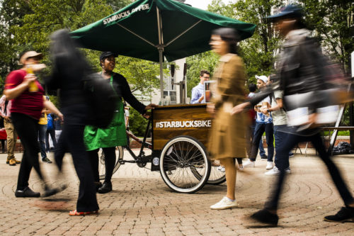 A Starbucks employee sells coffee from the Starbucks bike on Snell Quad on September 13, 2018. Photo by Adam Glanzman/Northeastern University
