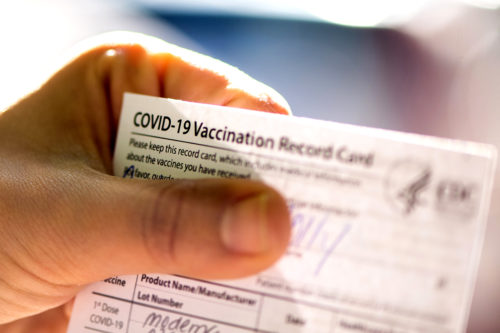 A vaccination card is held.