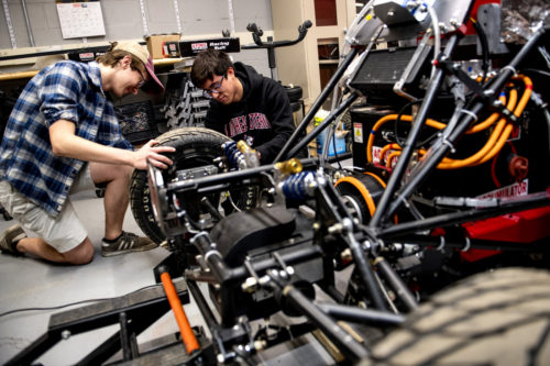 Northeastern Electric Racing club members Casey Sauer, who studies mechanical engineering and James Chang-Davidson, who studies computer science, tune up the all-electric Formula One-style race car for a calibration test run. Photo by Matthew Modoono/Northeastern University