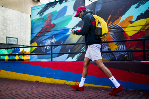  A member of the Northeastern community walks by the Felipe Ortiz mural Plumage, on Huntington Ave. Photo by Alyssa Stone/Northeastern University