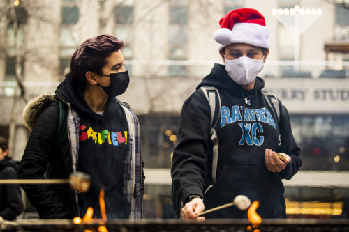 Members of the Northeastern community roast marshmallows for s'mores in Snell Quad, courtesy of the Northeastern University police officers  to help ease finals -week stresses. Photo by Alyssa Stone/Northeastern University