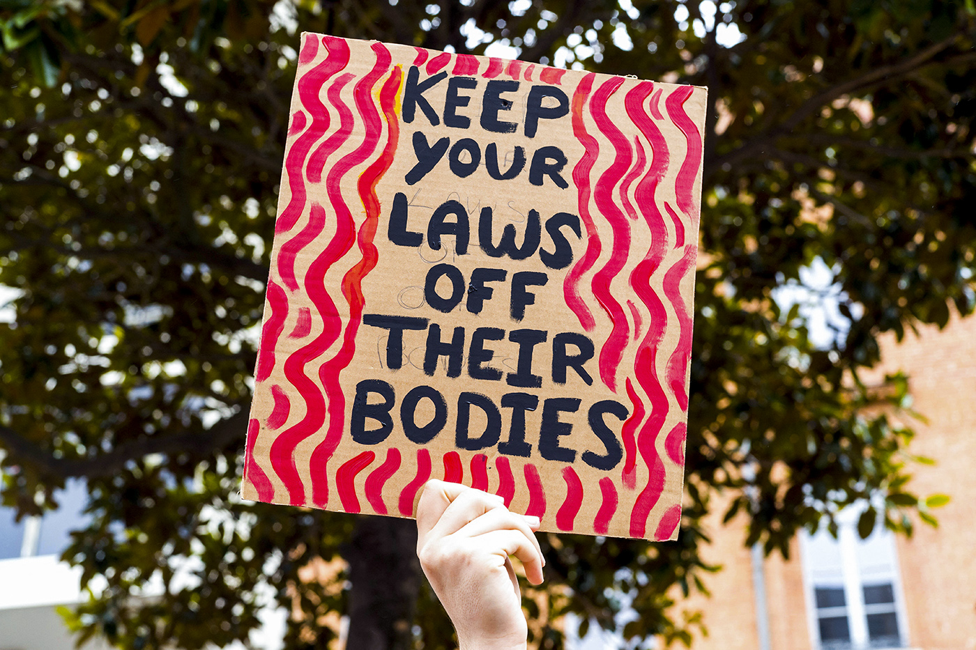 protest sign that says 'keep your laws off their bodies'