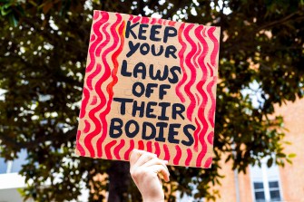 protest sign that says 'keep your laws off their bodies'