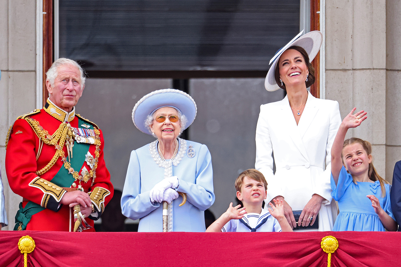 queen elizabeth standing next to princess kate middleton, prince louis, princess charlotte, and prince charles