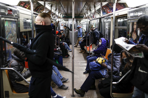 Subway customers wear masks on a crowded car heading downtown, on  March 17, 2020, in New York. AP Photo by John Minchillo