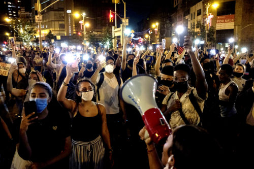 Demonstrators raise their mobile phone lights during a protest in support of the Black Lives Matter movement and other groups in New York, the United States. Photo by Stringer/Sputnik via AP