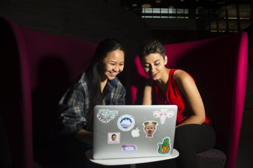 Danielle Nguyen and Niousha Jafari, of NU Hacks work on a laptop in ISEC. Photo by Adam Glanzman/Northeastern University