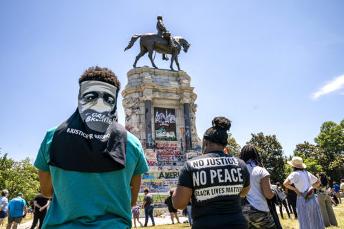 People gather at the Robert E. Lee Monument, now covered by protest graffiti, in Richmond, Virginia on June 7, 2020, following a week of unrest in the U.S. against police brutality and racism in policing. The statue of the Confederate Civil War general is slated for removal at the order of Gov. Ralph Northam. (AP Photo by J. Scott Applewhite