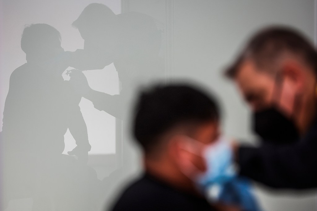 blurred image of a man receiving a covid vaccination