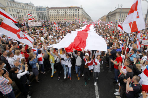 Demonstrators carry historical flags of Belarus as thousands gather for a protest at the Independence square in Minsk, Belarus, on Aug. 23, 2020. Demonstrators are taking to the streets of the capital and other cities, keeping up their push for the resignation of the nation's authoritarian leader. President Alexander Lukashenko has extended his 26-year rule in a vote the opposition saw as rigged. AP Photo by Dmitri Lovetsky