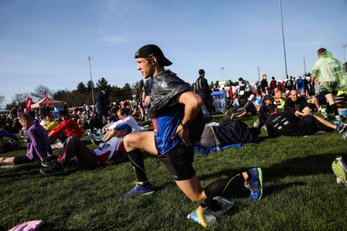 Runner Andrew Nowak stretches in the Athletes' Village prior to 120th Boston Marathon in Hopkinton, Mass., on April 18, 2016. Photo by Keith Bedford/The Boston Globe via Getty Images