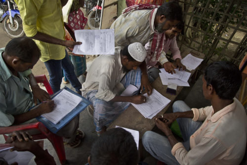 People whose names were left out in the National Register of Citizens (NRC) draft  fill their forms to file appeals near a NRC center on the outskirts of Gauhati, India, Monday, Aug. 13, 2018. A draft list of citizens in Assam, released in July, put nearly 4 million people on edge to prove their Indian nationality. AP Photo/Anupam Nath