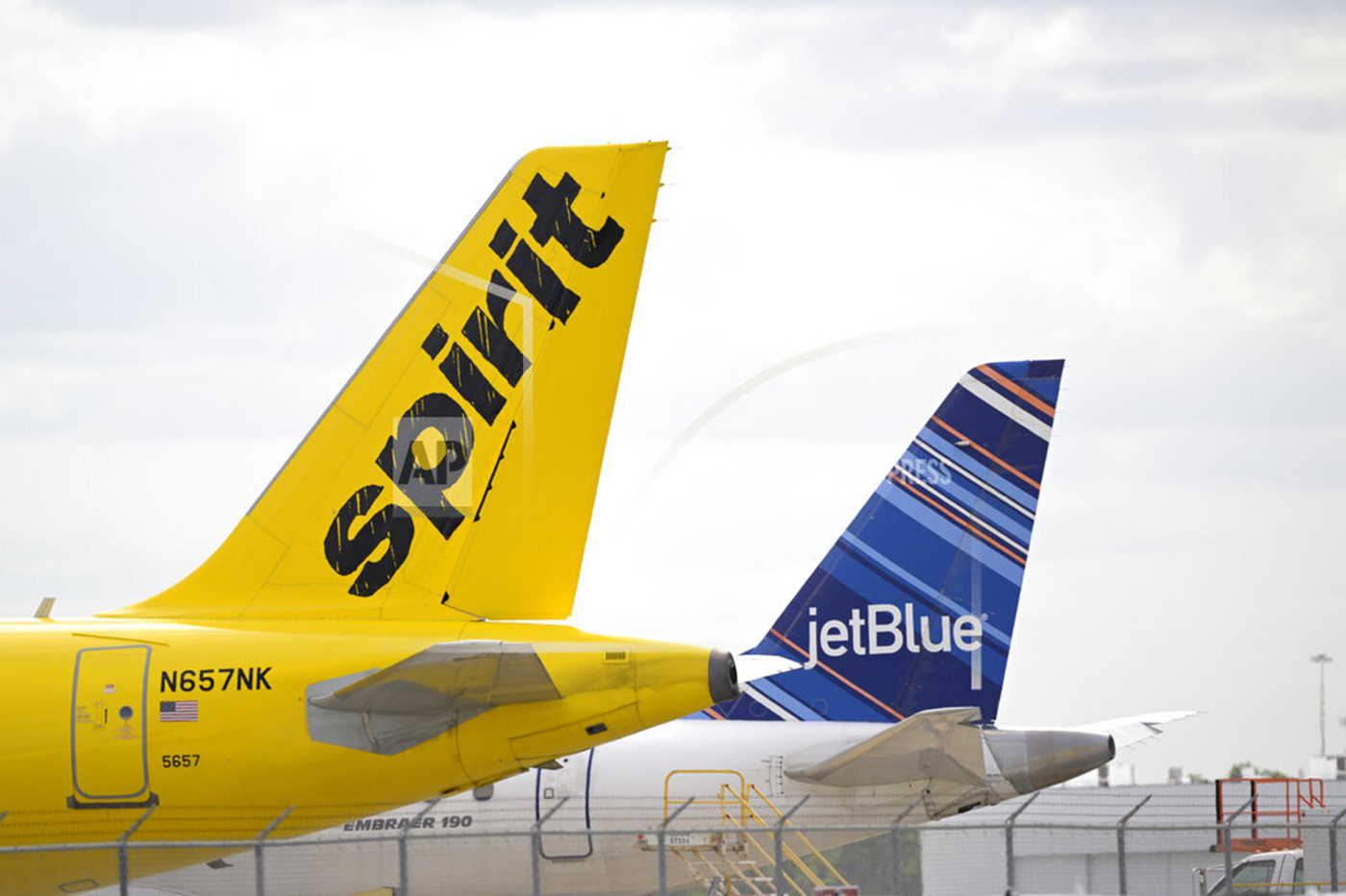 tail wing of spirit airlines and jetblue airlines planes next to each other