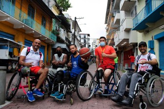 group of people in wheelchairs with one holding a basketball