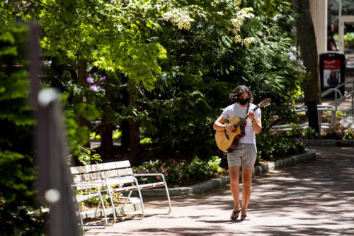 Gabriel Katz, who studies mechanical engineering, strolls and strums while walking outside of Curry Student Center. Photo by Ruby Wallau/Northeastern University