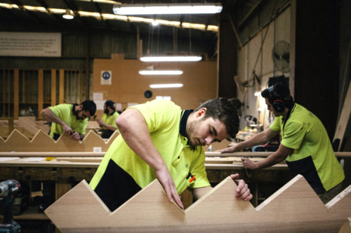 Northeastern student Chase Bivona smooths out the rough edges of a stringer—the foundation component of a staircase—as part of his structural engineering co-op in Braeside, Australia. Photo by Ying Ang for Northeastern University