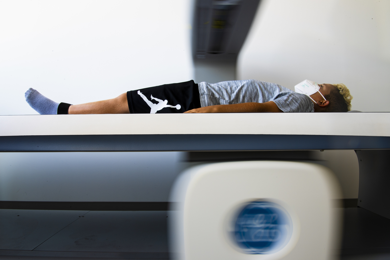 A study participant lays on a flat surface under a x-ray maching