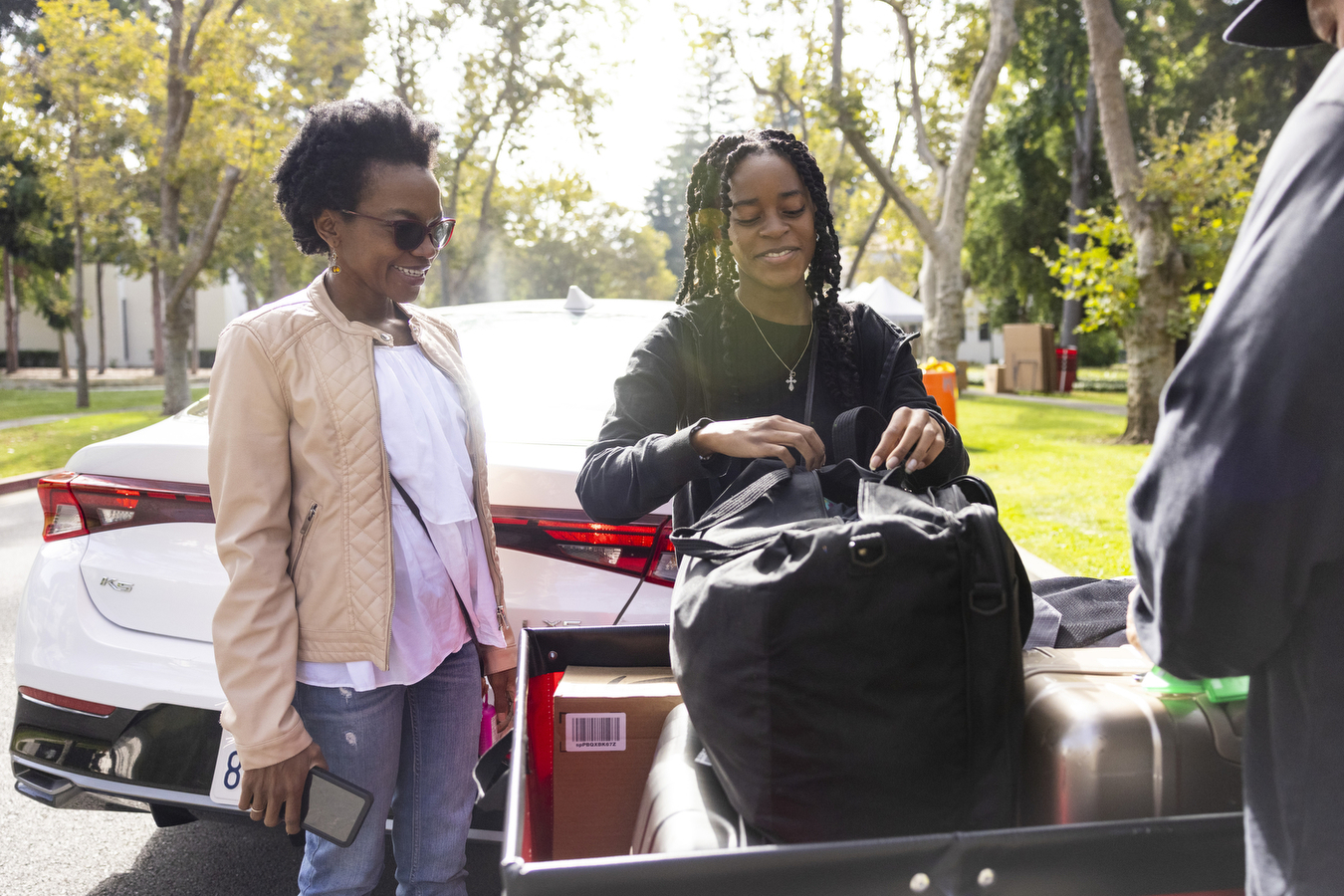 A family unpacks belongings from a car