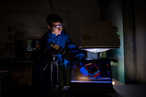 Andrew Caratenuto, who studies mechanical engineering, tests cooling performance under solar simulator on a scaled down building in the Mugar Life Sciences Building on Tuesday July 5, 2022. Photo by Matthew Modoono/Northeastern University