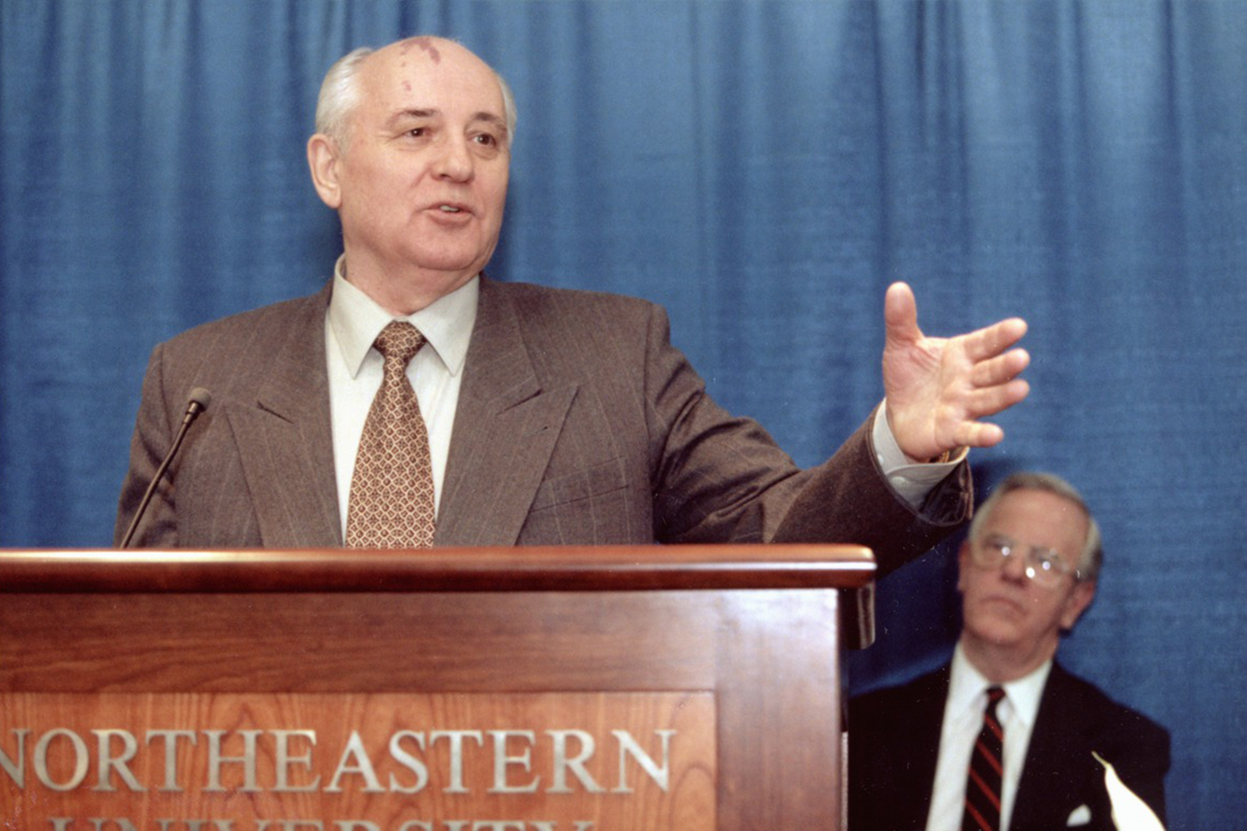 Mikhail Gorbechev stands at a podium with the words 'Northeastern University' on the front