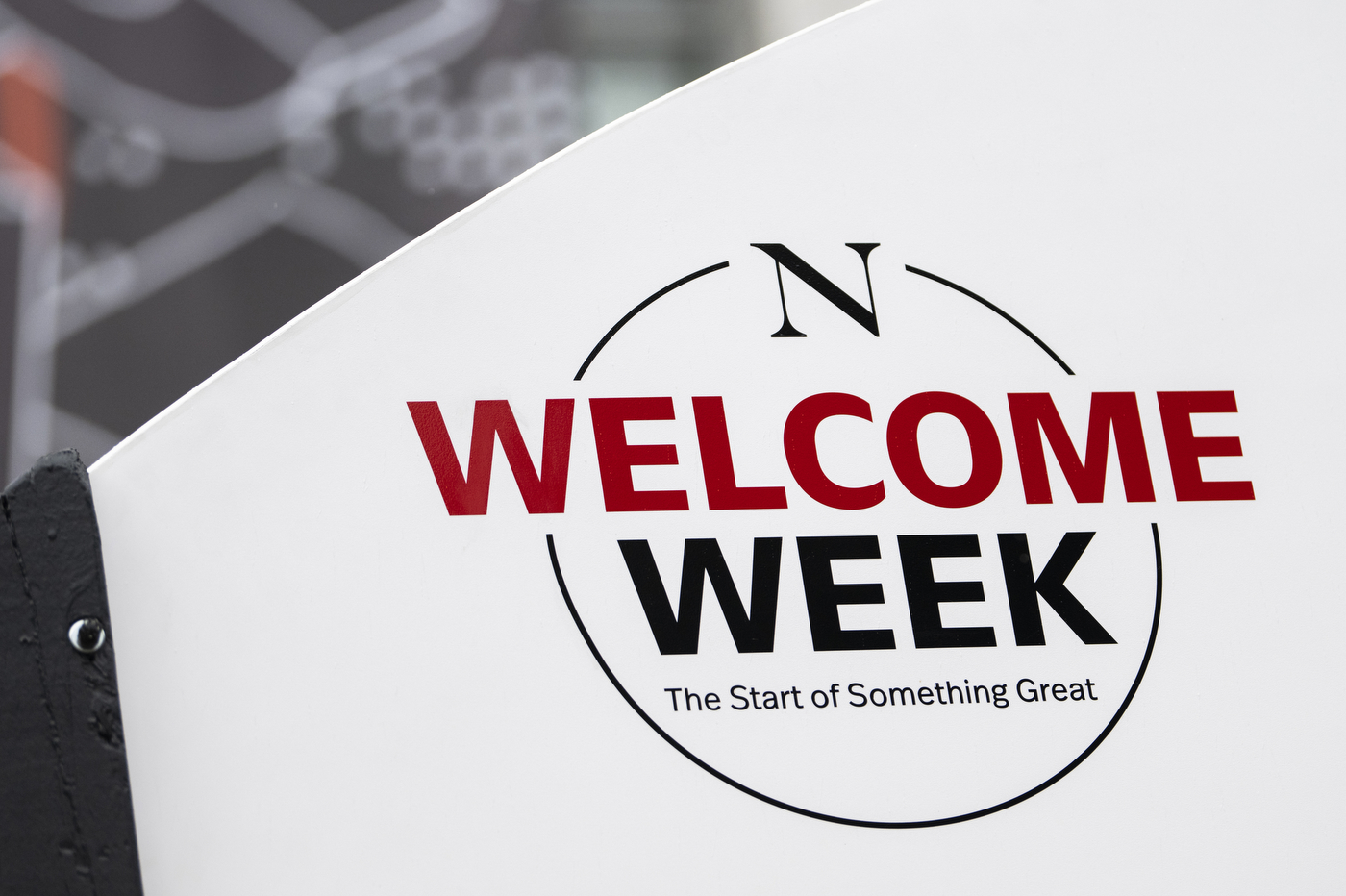 A white board has black and red text over it: "Welcome Week: The Start of Something Great," for Northeastern's Convocation.