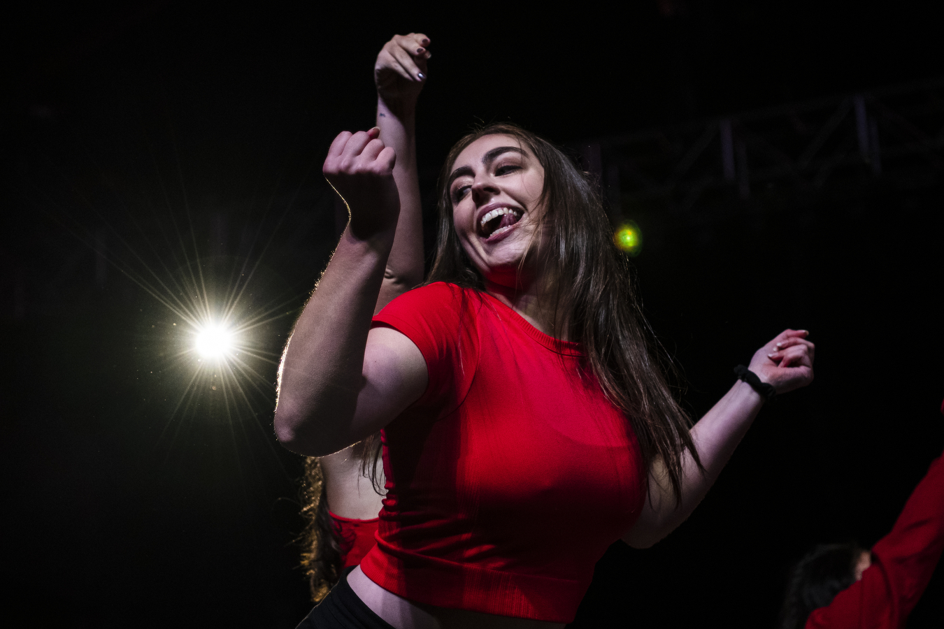 A person wearing a bright red shirt is dancing at Northeastern's 2022 Convocation.