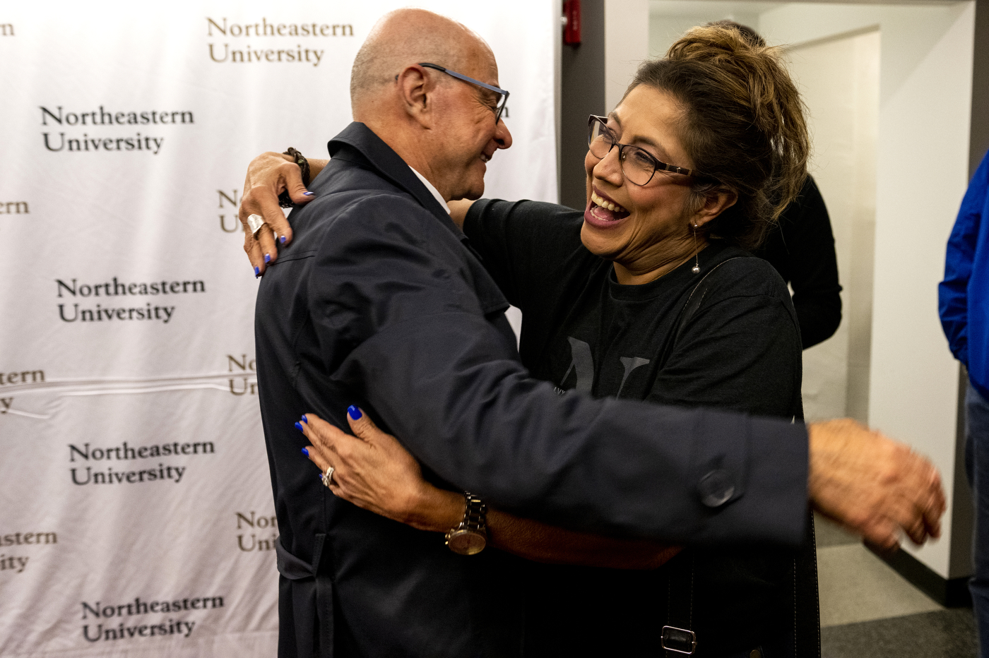 President Aoun is hugging the mother of a college student at Northeastern's Convocation. 